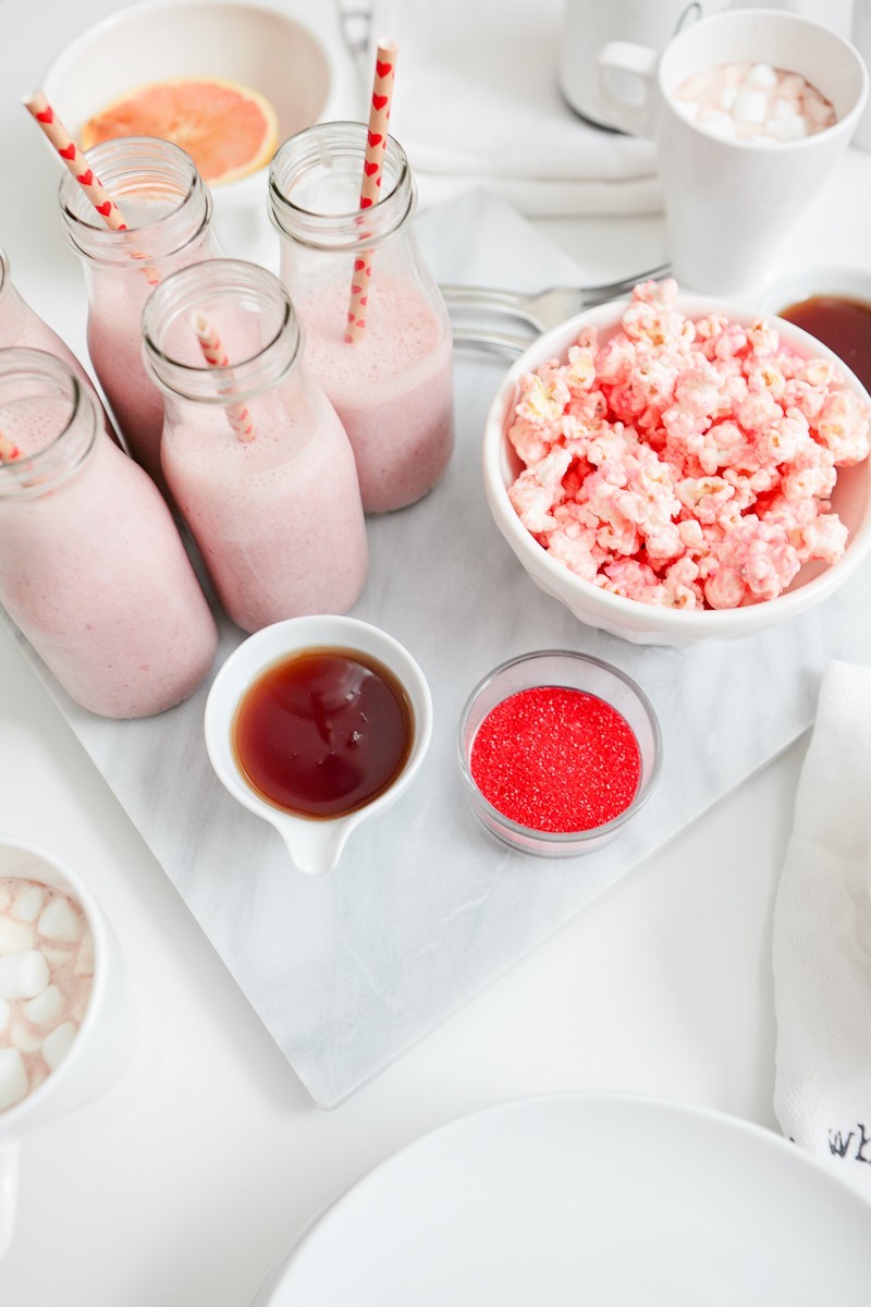 Valentine's Day Brunch that the entire family with love... complete with the cutest EASY heart shaped pancakes and strawberries, pink smoothies and a pink candied popcorn recipe! Host a galentine's brunch or serve your valentines a breakfast they'll remember!
