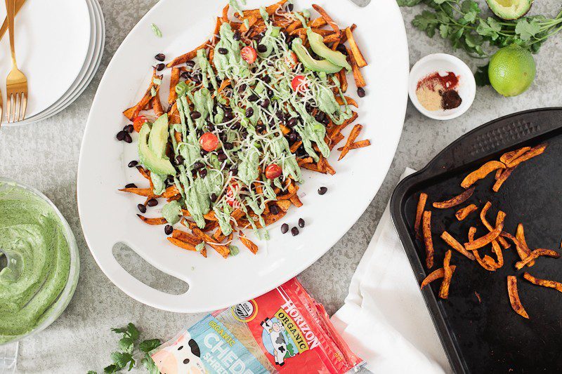Loaded Sweet Potato Mexican Street Fries with Avocado Lime Dressing! A skinny and delicious twist on a loaded fry platter that won't mess with your waistline or derail your resolutions! Need a dinner to drool over? Try these Loaded Sweet Potato Mexican Street Fries! A skinny and delicious twist on a loaded fry platter that won't mess with your waistline or derail your resolutions! A healthy and hearty recipe from Tabitha Blue of Fresh Mommy Blog with Horizon.