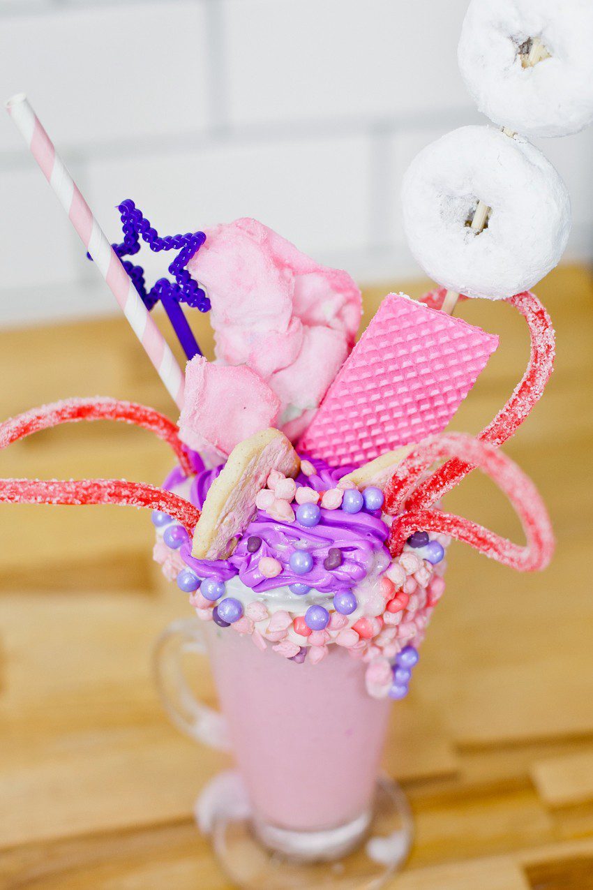 These Epic Royal Crazy shakes are indulgently MAGICAL! A rich, thick strawberry milkshake is topped with a sugaring of sprinkles and candies to make a delicious crazy shake drink fit for a princess... or a prince. A pretty in pink and purple freak shake!