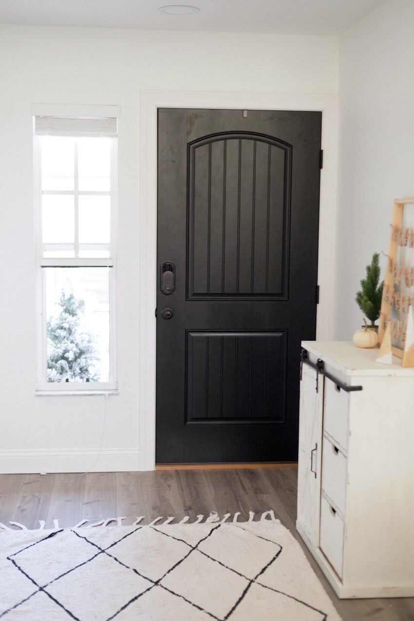 Modern farmhouse front entryway makeover reveal! Open your front door to guests this Christmas season with an updated front door. Black and white with wood natural elements make a welcoming statement and up the curb appeal.