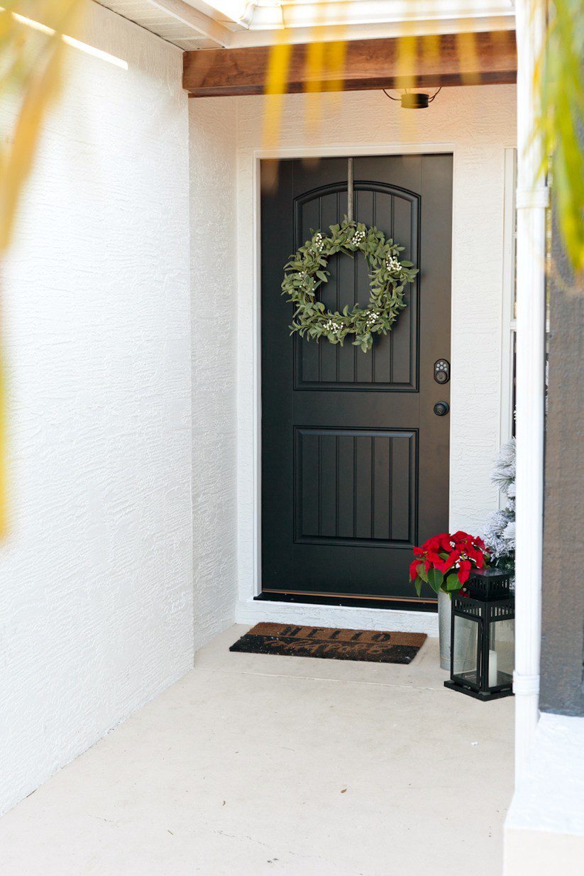 Modern farmhouse front entryway door makeover reveal! Open your front door to guests this Christmas season with an updated front door. Black and white with wood natural elements make a welcoming statement and up the curb appeal.