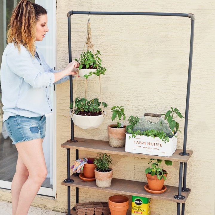 woman watering plants on a DIY rolling plant shelf for portable hanging garden
