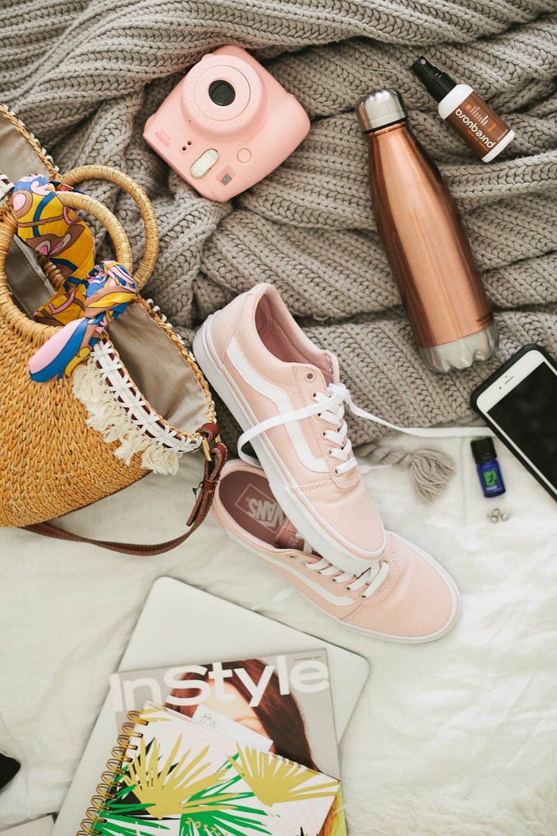 Road Trip Essentials and The Ultimate Road Trip Playlist with music for a happy, adventurous trip. - Travel Essentials: The Ultimate Road Trip Playlist by popular Florida lifestyle blogger Fresh Mommy Blog | Family Road Trip Playlist by popular Florida travel blog, Fresh Mommy Blog: image of a pink Polaroid camera, pink Vans sneakers, inStyle magazine, laptop, water bottle, smartphone and woven handbag. 