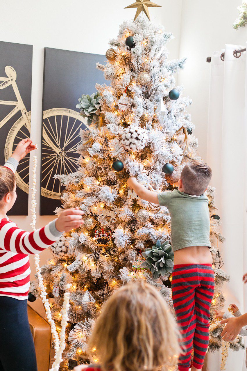 How to Host your Own Festive Tree Trimming Party from top Florida lifestyle blogger Tabitha Blue of Fresh Mommy Blog: image of children putting up their homemade Christmas tree decorations