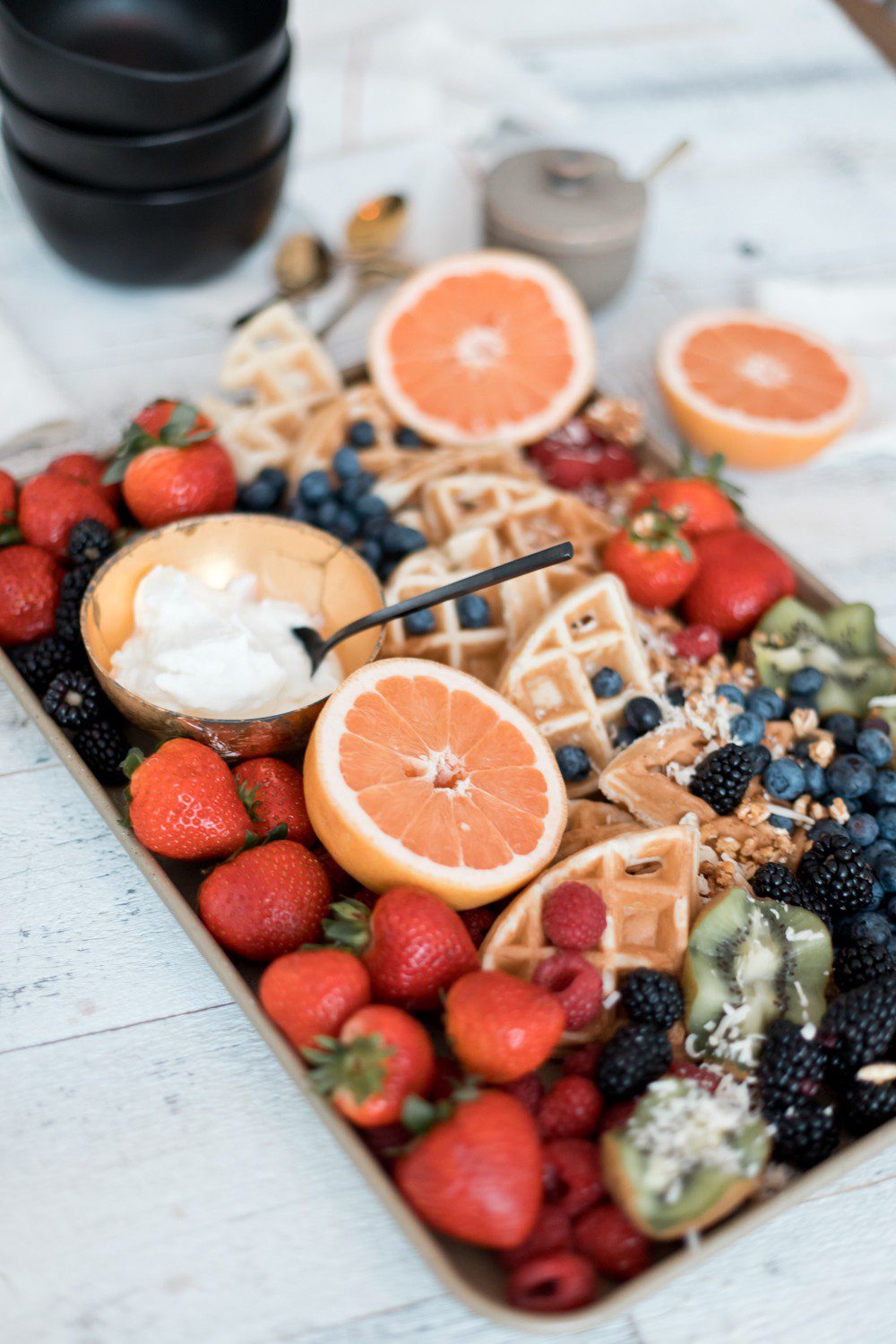  DIY Yogurt Parfait Recipe Ideas with Protein for Kids They'll Love by popular Florida lifestyle blog, Fresh Mommy: image of kiwis, strawberries, blackberries, blueberries, coconut, grapefruits, waffles, and Fage greek yogurt on a tray.