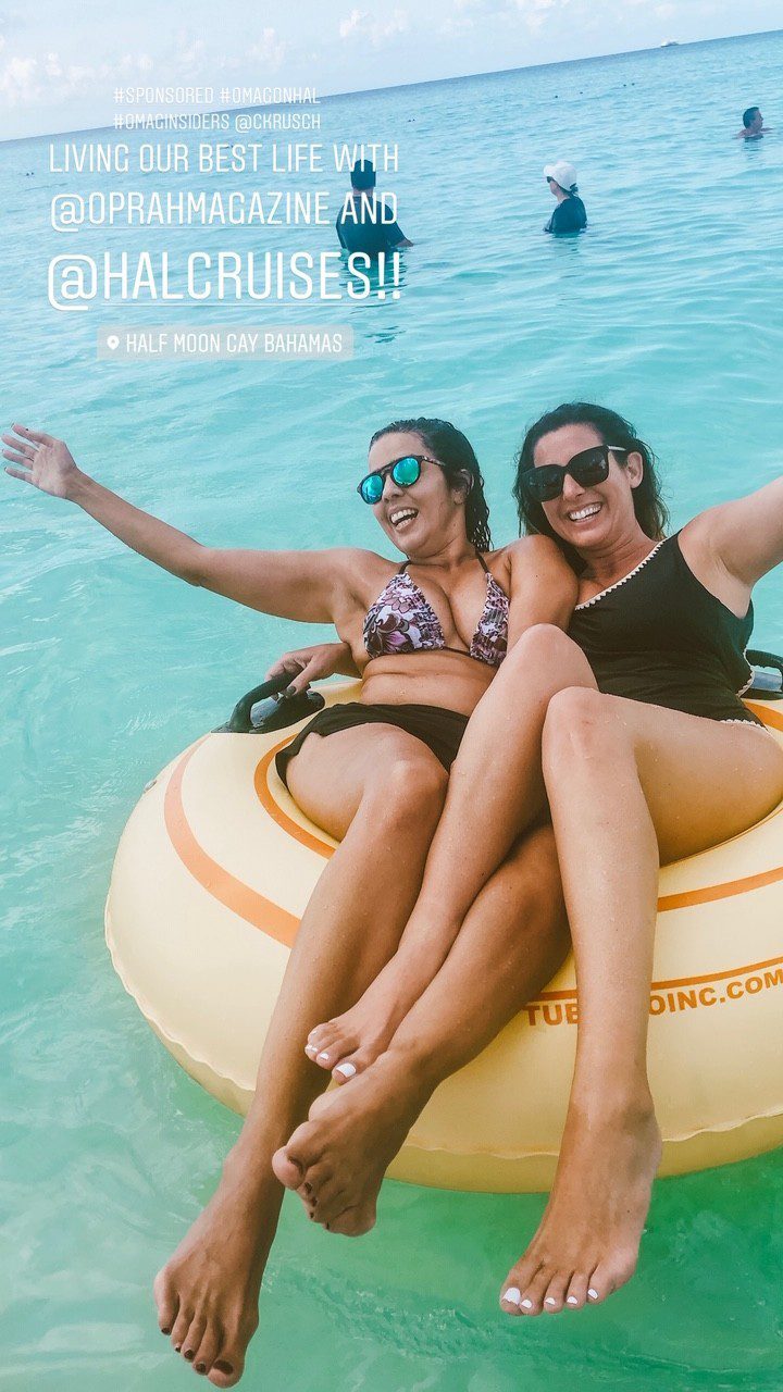 5 Amazing Reason to go on a Holland America cruise with Oprah Magazine by popular US lifestyle blog Fresh Mommy Blog: image of two women wearing swimsuits and sunglasses and sitting on yellow inner tube in the Caribbean ocean during their Holland America cruise.