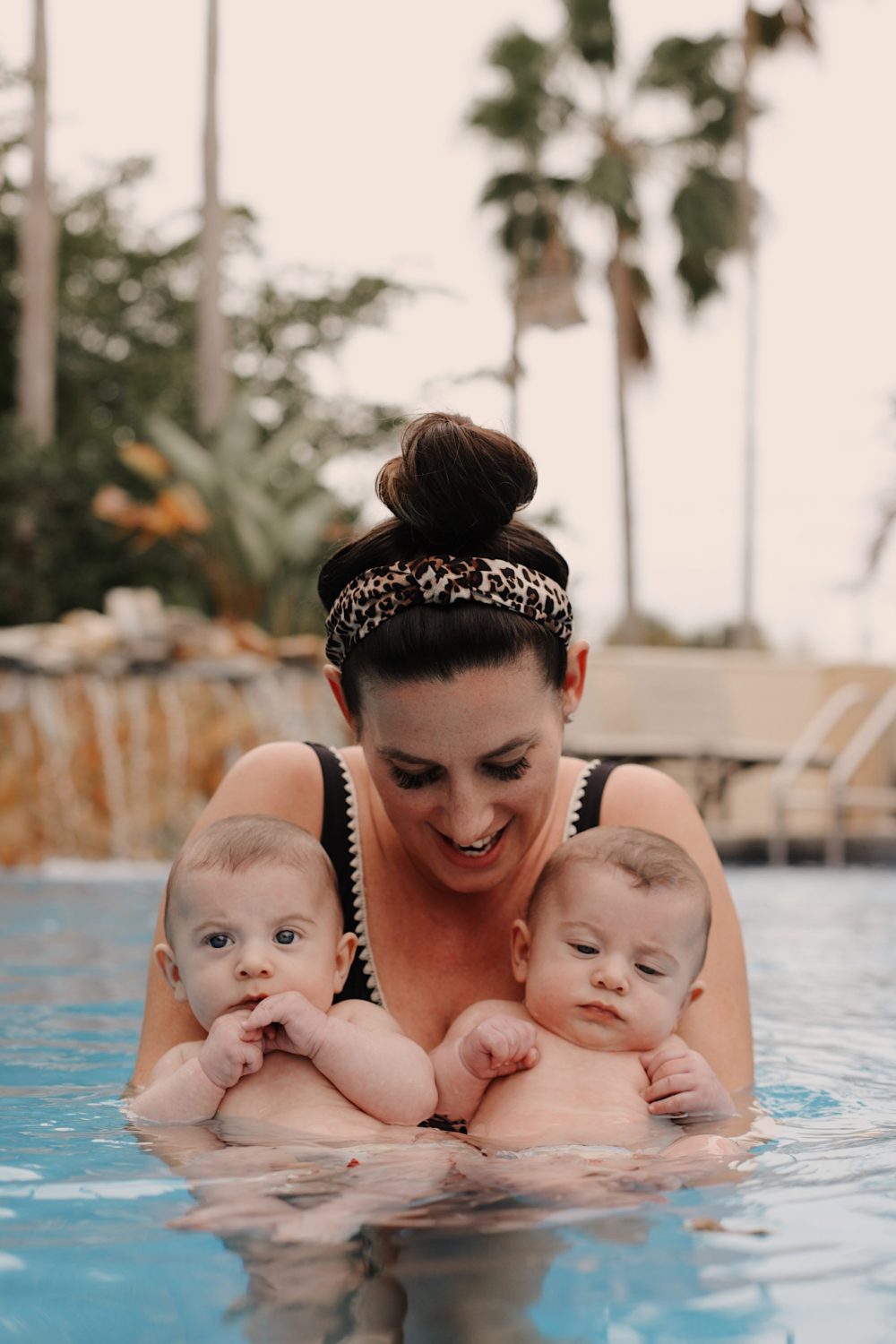 Mom holding twin babies in the pool. Spectacular Things to Do in Naples This Weekend | Spectacular Things to Do in Naples FL This Weekend by popular Florida blog, Fresh Mommy Blog: image of a mom holding her twin babies in a pool. 