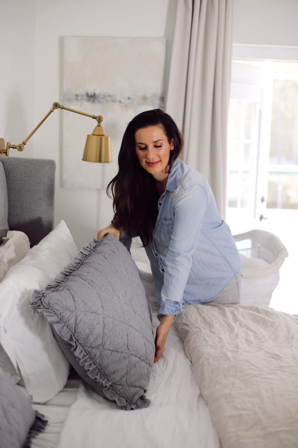 how to Make your Bed Comfortable Like a Hotel in 7 Easy Steps, a tutorial featured by top Florida lifestyle blog, Fresh Mommy Blog. | Best Bedding by popular Florida life and style blog, Fresh Mommy: image of a woman making a comfortable bed. 