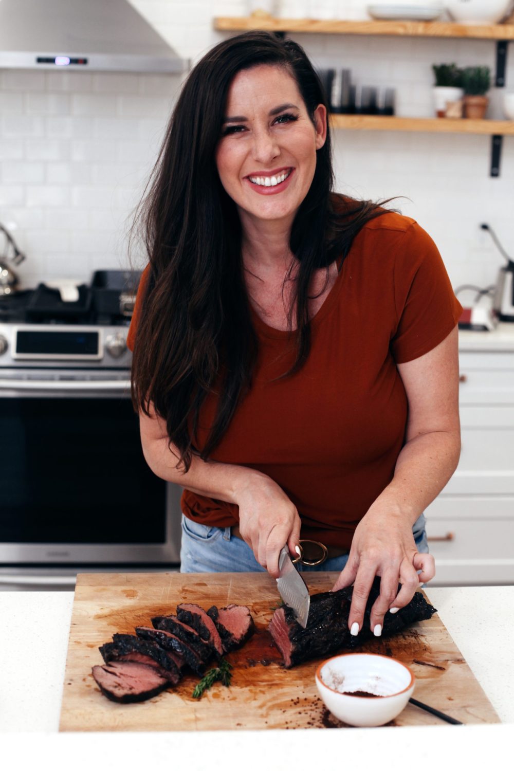 Best Way to Cook Beef Tenderloin with Espresso Crusted Chateaubriand Recipe from top Florida lifestyle blogger Tabitha Blue of Fresh Mommy Blog. How to get deliciously tender steak every time and the best coffee steak rub. | Best Beef Tenderloin by popular Florida lifestyle blog, Fresh Mommy Blog: image of a woman slicing Espresso Crusted Chateaubriand beef tenderloin. 