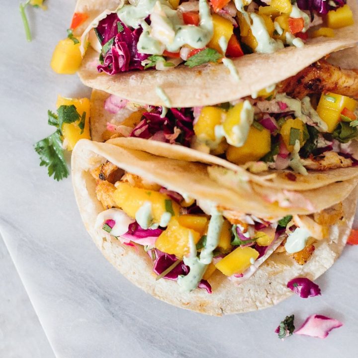 Blackened Fish Tacos with Mango Salsa, Cilantro Lime Sauce and Mexican Street Corn! It's SO good (even approved from someone who doesn't really like fish)