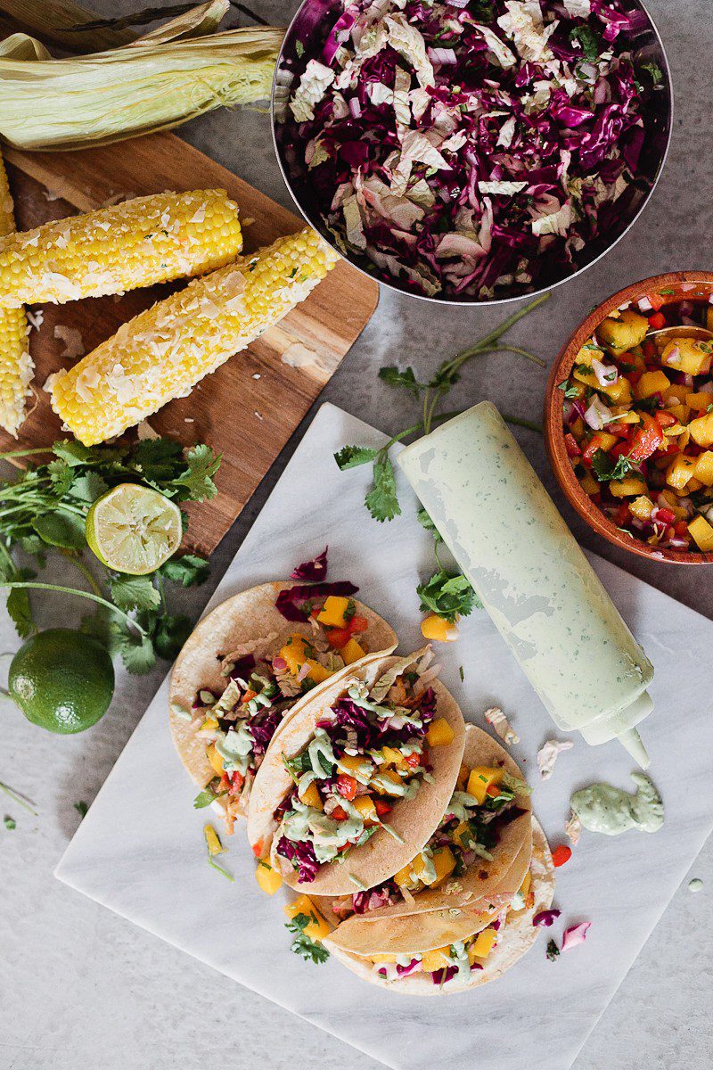 Blackened Fish Tacos with Mango Salsa, Cilantro Lime Sauce and Mexican Street Corn! It's SO good (even approved from someone who doesn't really like fish)