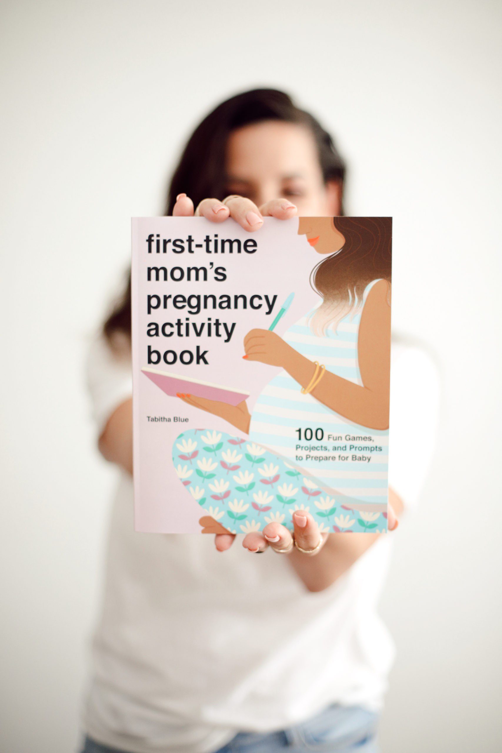 holding first time mom's pregnancy activity book | First Time Mom's Pregnancy Activity Book by popular Florida motherhood blog, Fresh Mommy Blog: image of a woman holding a copy of the First Time Mom's Pregnancy Activity Book. 