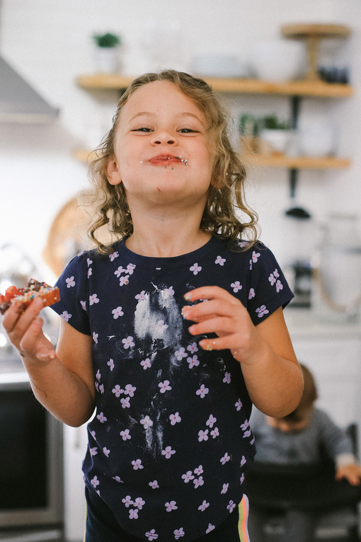 Easy snack ideas for a healthy sweet snacktivity for kids! Apple Donut fun recipe for kids from top Florida blogger Tabitha Blue of Fresh Mommy Blog | Apple Donuts by popular Florida motherhood blog, Fresh Mommy Blog: image of a young girl eating a apple donut. 