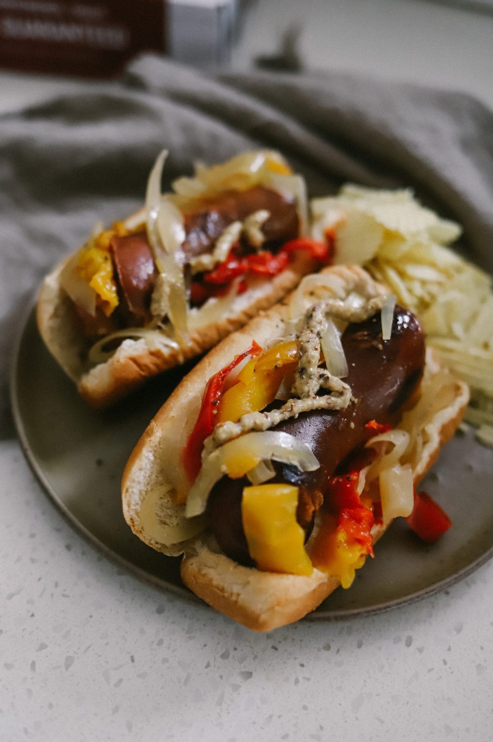 Crockpot Recipes: The Best Slow Cooker Beer Brats | Grilling Season by popular Florida lifestyle blog, Fresh Mommy Blog: image of beer brats on buns with onions and peppers. 