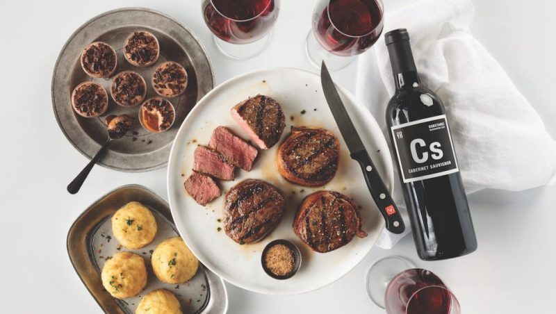 Omaha Steaks Gifts by popular Florida lifestyle blog, Fresh Mommy Blog: image of a plate of steaks next to a bottle of red wine and wine glasses filled with red wine. 