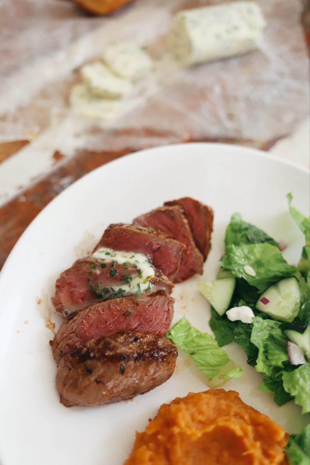 Homemade Steak Butter: How to Make an Easy Steakhouse Herb Butter for Steak |Steak Butter by popular Florida lifestyle blog, Fresh Mommy Blog: image of slices pieces of steak with melted steak butter on top. 