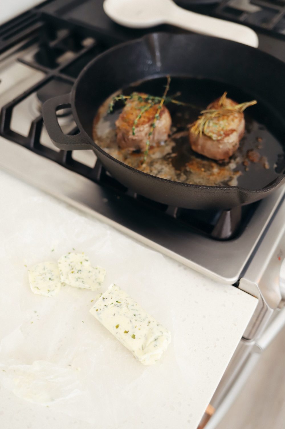 Homemade Steak Butter: How to Make an Easy Steakhouse Herb Butter for Steak |Steak Butter by popular Florida lifestyle blog, Fresh Mommy Blog: image of steak cooking in a skillet next to some herb steak butter. 