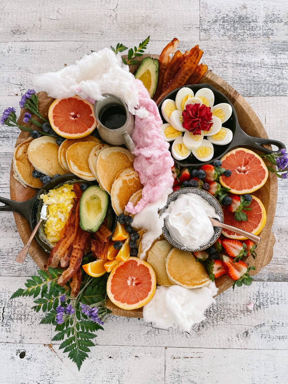 How to Make a Pancake Board That Looks as Delicious as It Tastes. The best Spring Breakfast Board |Pancake Board by popular Florida lifestyle blog, Fresh Mommy Blog: image of a pancake board with pancakes, grapefruit, blueberries, avocado, deviled eggs, bacon, scrambled eggs, and strawberries.