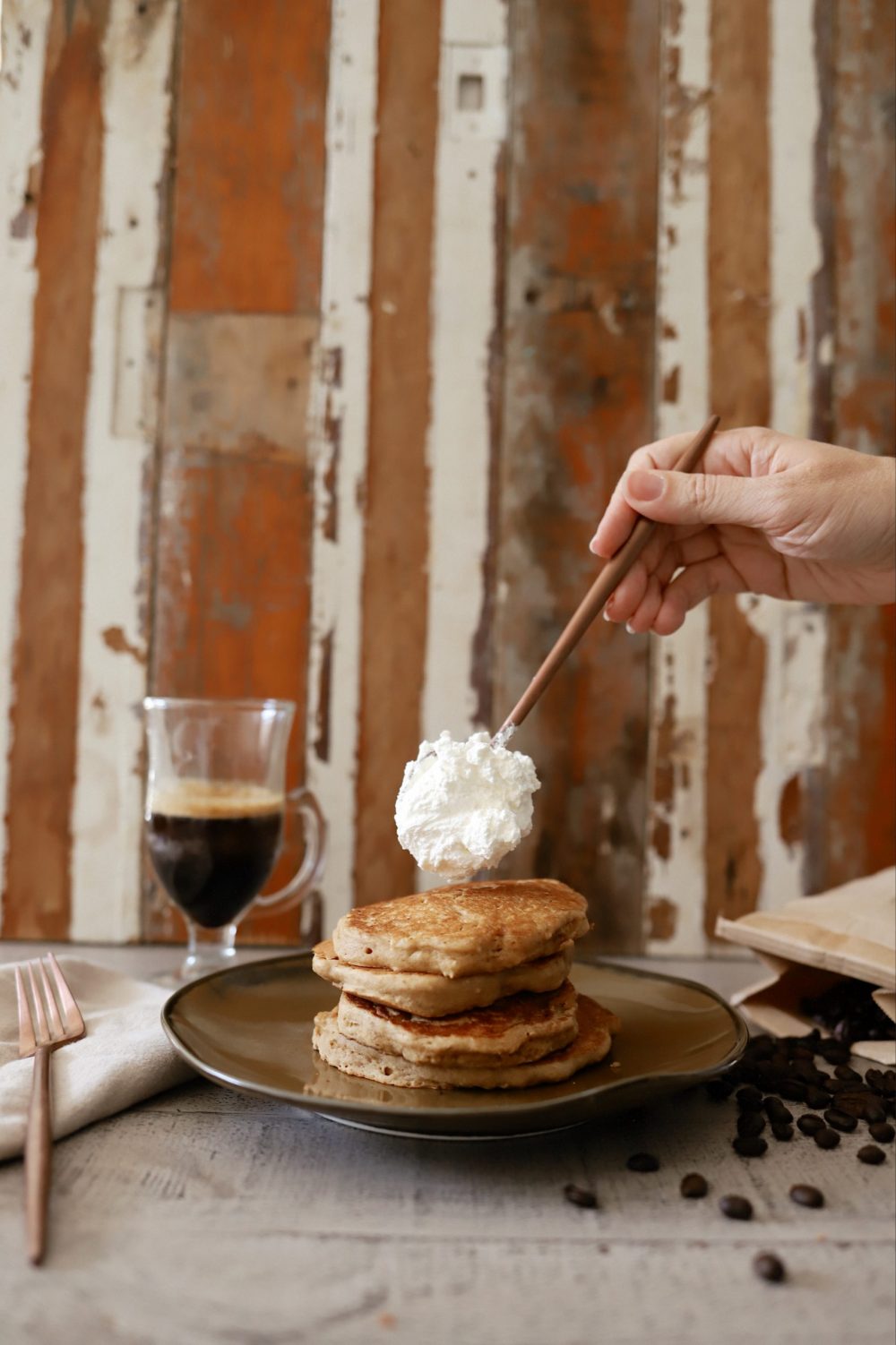 Mouthwatering Coffee Pancakes With Espresso and Vanilla Cream Whip | Coffee Pancakes by popular Florida lifestyle blog, Fresh Mommy Blog: image of whipped cream being placed on top of some stacked coffee pancakes. 
