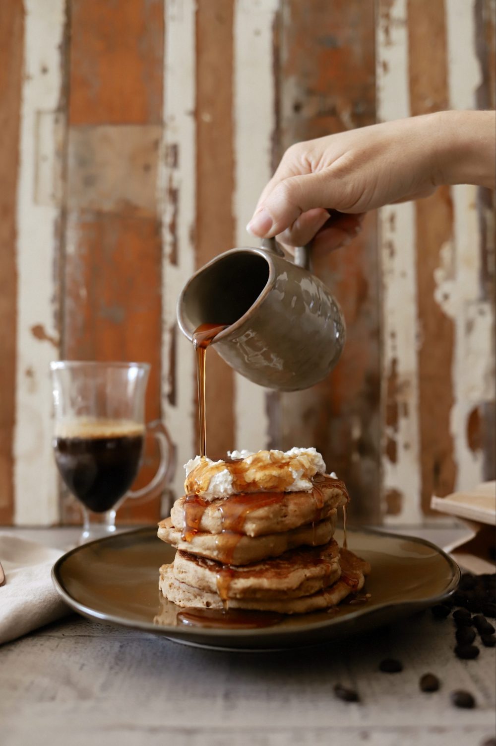 Mouthwatering Coffee Pancakes With Espresso and Vanilla Cream Whip | Coffee Pancakes by popular Florida lifestyle blog, Fresh Mommy Blog: image of some syrup being poured onto stacked pancakes. 